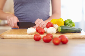 Cooking is an artform. Cropped image of a woman chopping up vegetables in the kitchen.