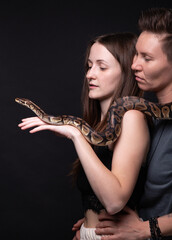 Photo of two hugging women with python on shoulders