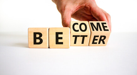 Become better symbol. Businessman turns wooden cubes and changes the concept word Better to Become. Beautiful white table white background. Business become better concept. Copy space.