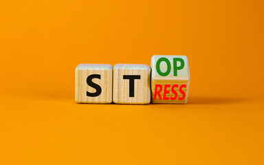 Stop stress and be health symbol. Turned the wooden cube and changed the concept words Stress to Stop. Beautiful orange background. Psychological business and stop stress concept. Copy space.