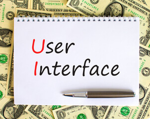 UI user interface symbol. Concept words UI user interface on white note. Metallic pen. Dollar bills. Beautiful white background. Copy space. Business and UI user interface concept.