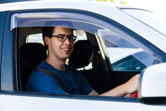 Happy young driver in his twenties with his first car