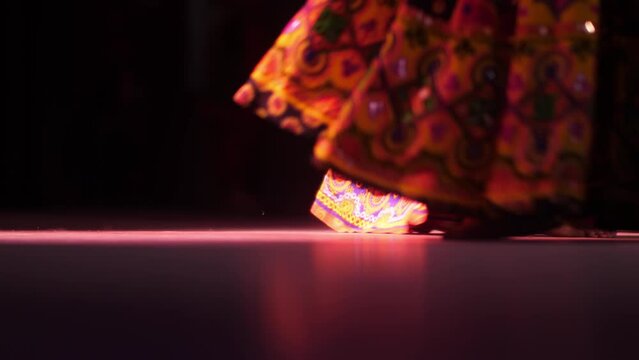 A group of girls dance a cultural dance of India. Close-up of women's feet in Indian outfits.