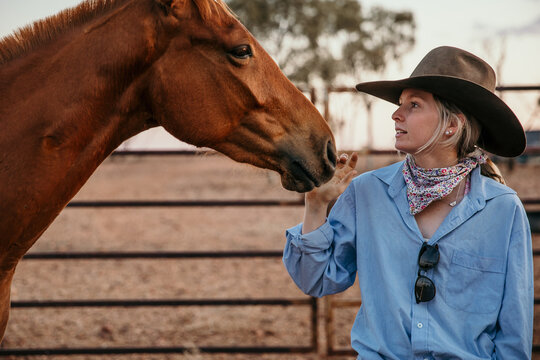 Cowgirl patting horse