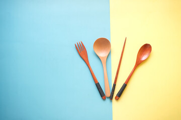 wooden cutlery forks on light yellow background 