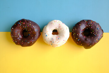 Close up of many chocolate donuts on color background 