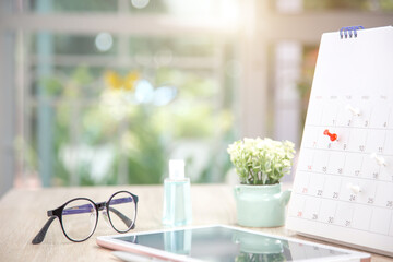 Close up pin on business desk calendar with office equipment concept of event planner or personal organization reminder and schedule or planning.