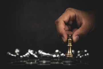Hand choose king chess with chess falling in the back for fight on chess board concept of team player or business team and leadership strategy and human resources organization management.