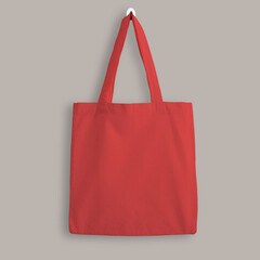 Red blank cotton eco tote bag, design mockup. Shopping bag hanging on wall