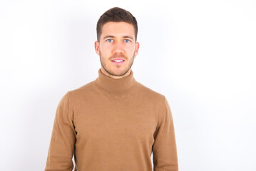 young caucasian man wearing grey turtleneck over white background with a happy and cool smile on face. Lucky person.