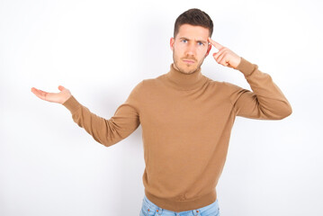 young caucasian man wearing grey turtleneck over white background confused and annoyed with open...