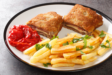 Cachopo with fried potatoes, typical meat dish from Asturias, Spain closeup. Horizontal