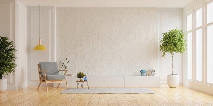 Cabinet for TV on the white plaster wall in living room with armchair,minimal design.