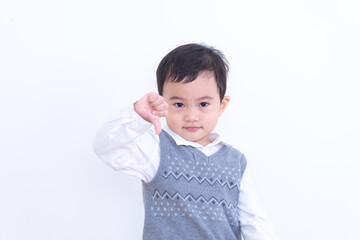 Asian little boy giving thumbs down on white background.