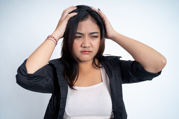 Fototapeta premium Young woman holding head while confused by situation