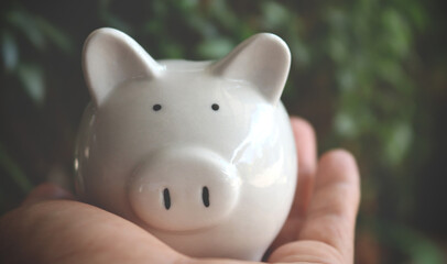 hand man holding piggy banck carefully.  saving money for retirement concept. Vintage style.