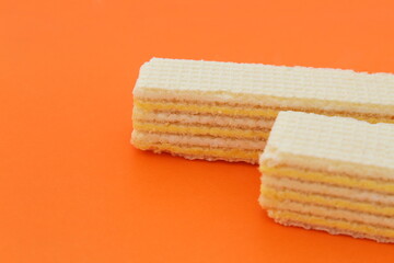 Fototapeta premium Two waffles lie on an orange background