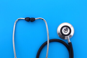 The stethoscope lies on a blue bright background.