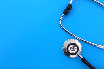  The stethoscope lies on a blue bright background.