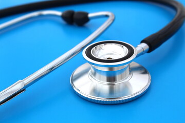 The stethoscope lies on a blue bright background.