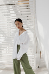 Beautiful and stylish girl with Asian appearance in a minimalist interior