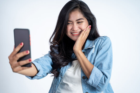 young woman make a video call using mobile phone on isolated background