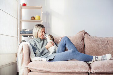 Serene woman housewife lounge sit on sofa hold hands behind head at home