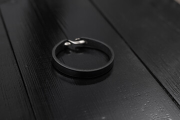 Black leather male bracelet on the dark wooden desk