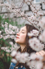 beautiful girl model in a denim jacket in spring garden in flowers