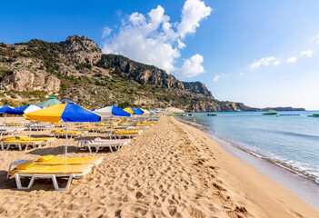 Sunbeds and umbrellas on Tsampika beach, Rhodes island, Greece