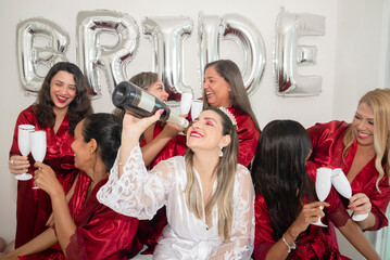 Bride and godmothers together with glass of champagne in hand in portrait against white background.