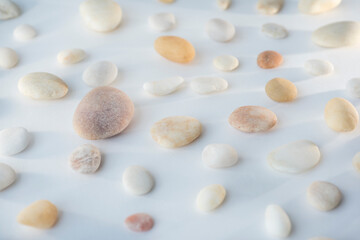 Fototapeta na wymiar pebbles of different shapes on white background and glittering.