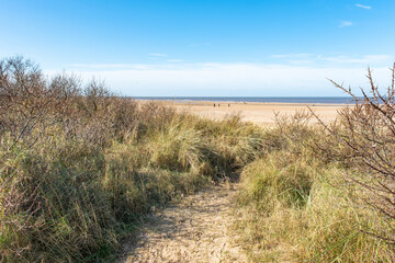 Fototapeta na wymiar A view over Hunstanton beach on the North Norfolk coast taken from the sand dunes. Captured on a bright and sunny day in the winter