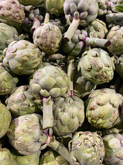 Obraz premium Organic raw artichokes in the grocery store. Vertical artichokes background. Vegetarian healthy food