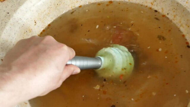 clogging in the kitchen sink-dirty dishwater accumulated in the sink-a person trying to open the kitchen sink with the sink pump,