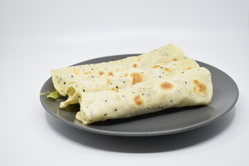 Arabic pita with cheese and greens on a gray plate. Light gray background.