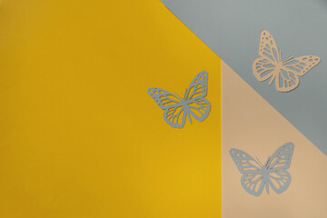 Flat Lay with Delicate Butterflies Cut Out of Paper on a Yellow, Beige and Blue Geometric...