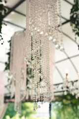 Naklejka na ściany i meble Beautiful luxurious romantic decor for a wedding celebration. The arch is decorated with draped fabric and a crystal chandelier.