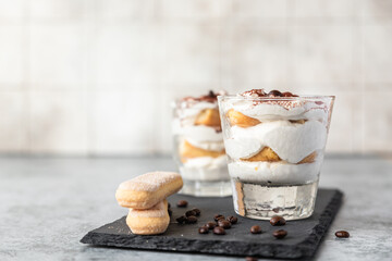 Traditional Italian dessert tiramisu in glasses. Coffee flavored Italian dessert made of ladyfingers and mascarpone.