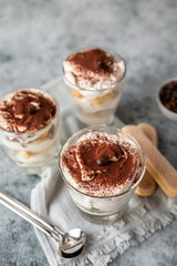 Traditional Italian dessert tiramisu in glasses. Coffee flavored Italian dessert made of ladyfingers and mascarpone.