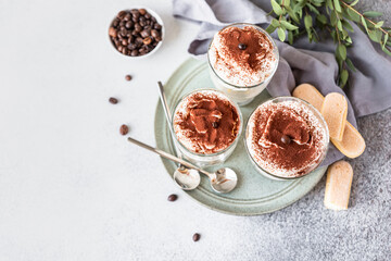 Traditional Italian dessert tiramisu in glasses. Coffee flavored Italian dessert made of ladyfingers and mascarpone.