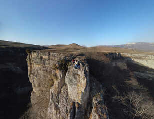 Fototapeta premium Lovers sit on the edge of a cliff