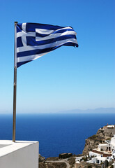 Flag of Greece.Thira on the island of Santorini is a volcanic island in the Aegean Sea, which is part of the Cyclades archipelago.Multi-coloured abstrakt architecture on island.