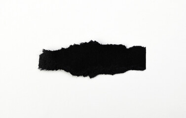 Black torn piece of paper on a white background.