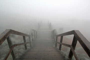 Foggy staircase with railing in high mointains