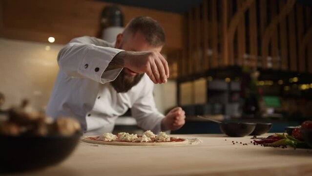 Professional chef making pizza dinner recipe in fine italian restaurant kitchen.