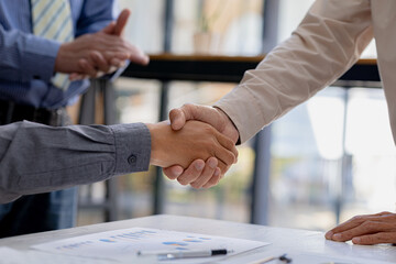 Business investor group holding hands, Two businessmen are agreeing on business together and shaking hands after a successful negotiation. Handshaking is a Western greeting or congratulation. - obrazy, fototapety, plakaty