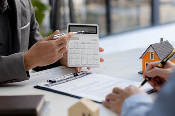 A rental company employee is calculating the cost for the customer to agree to sign a rental contract, explaining the rental terms and conditions. Home and real estate rental ideas.