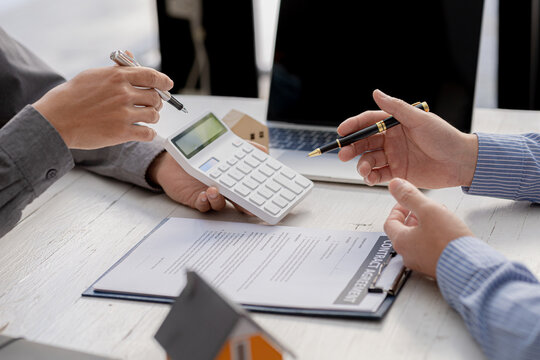 A rental company employee is calculating the cost for the customer to agree to sign a rental contract, explaining the rental terms and conditions. Home and real estate rental ideas.