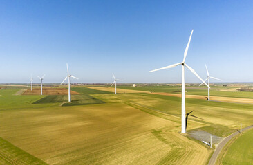 Fototapeta na wymiar Many wind turbine in the middle of the fields in the French countryside - renewable energy source, green energy against global warming - drone view